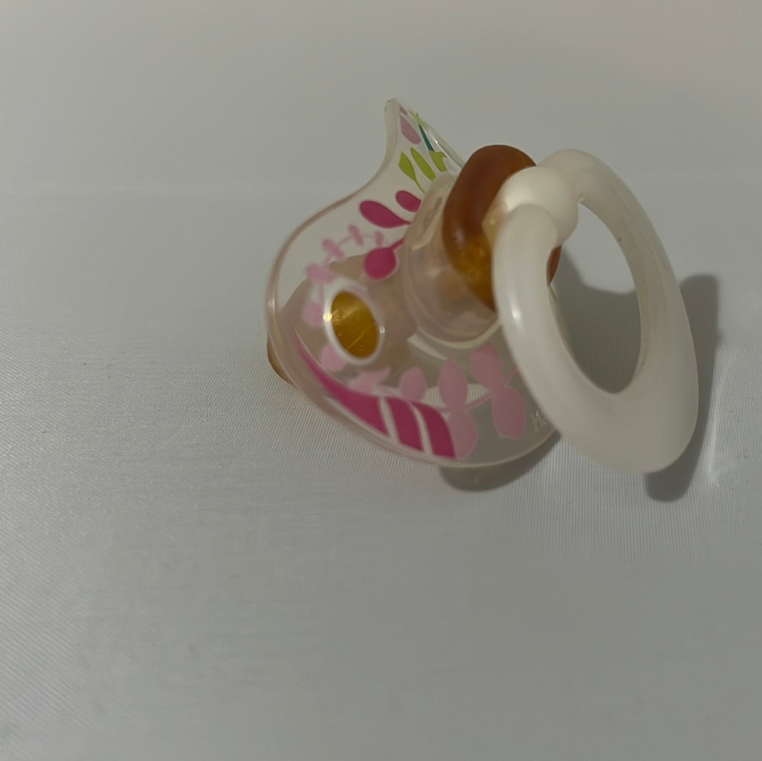 Translucent NUK Pacifier with floral pattern.